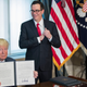 U.S. President Donald Trump (L), with Secretary of Treasury Steven Mnuchin (R), participate in a financial services Executive Order signing ceremony in the US Treasury Department building on April 21, 2017 in Washington, DC. President Trump is making his first visit to the Treasury Department for a memorandum signing ceremony with Secretary Mnuchin.